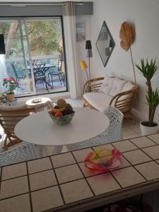 a living room with a table with a bowl of fruit on it at DUPLEX CAP D AGDE PISCINE in Cap d'Agde