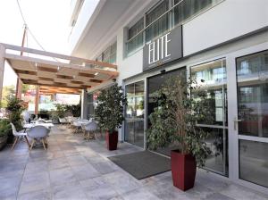 Elite Hotel في بلدة رودس: مطعم فيه طاولات وكراسي امام مبنى