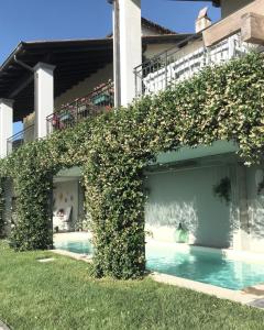 a ivy covered building with a swimming pool at Il Sassoscritto Bed and Breakfast in Montecalvo Versiggia