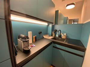 a small blue kitchen with a toaster and a sink at Modernes Apartment no5 in bester Stadtlage in Kassel