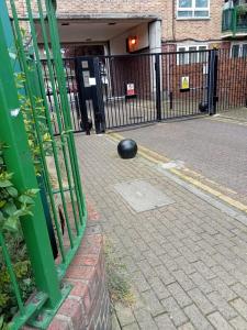 uma bola preta no chão ao lado de uma cerca em londesborough inn em Londres