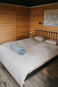 a large bed in a room with wooden walls at Vienkiemio oazė - Skandinaviškas namelis su vaizdu į tvenkinį in Galvokai