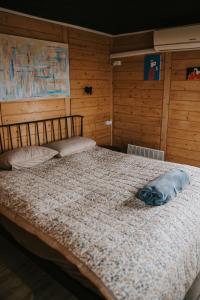 a large bed in a room with wooden walls at Vienkiemio oazė - Skandinaviškas namelis su vaizdu į tvenkinį in Galvokai