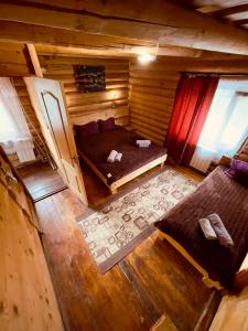 einen Blick über ein Schlafzimmer in einem Blockhaus in der Unterkunft Садиба Одеса in Podobovets