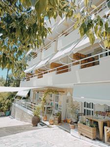 a facade of a building with tables and plants at Heras Garden in Vasiliki