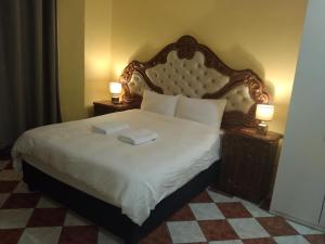 a bedroom with a large bed with two lamps on tables at Jacmo Guest house in Cape Town