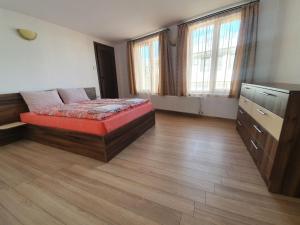 um quarto com uma cama, uma cómoda e janelas em Къща за гости Роден край 2 em Elena