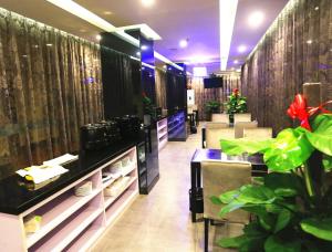 een restaurant met tafels en planten in een kamer bij Greentree Inn Mozitan Road Yiwu Small Commodities Wholesale City in Lu'an
