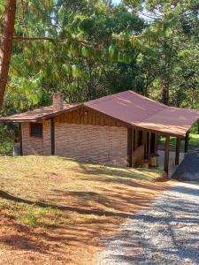 a small brick building with a pitched roof at Caminho do Sol in Monte Verde