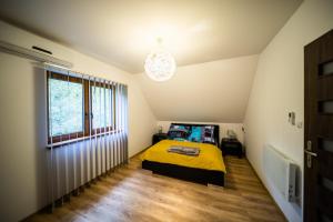 a bedroom with a yellow bed and a window at Domek w Sosenkach in Osłonin +15 photos