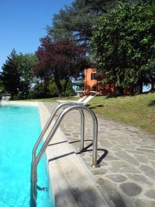 a swimming pool with a metal hand rail next to it at Villa Resta & Dependance in Castel San Pietro Terme