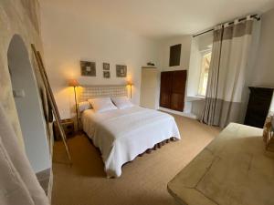 ein Schlafzimmer mit einem weißen Bett und einem Fenster in der Unterkunft Villa Verde - Gîte - possibilité table d'hôte in Boisseron