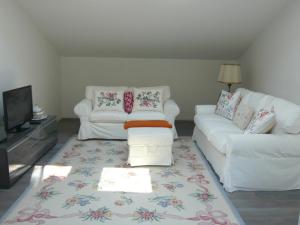 a living room with two white couches and a television at Villa Resta & Dependance in Castel San Pietro Terme
