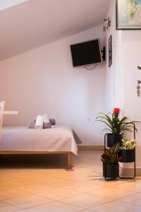 a bedroom with a bed and a tv on the wall at Apartments City Center Dekanić in Krk