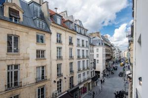 eine Stadtstraße mit Gebäuden und Menschen, die auf der Straße spazieren in der Unterkunft SUPER CENTRAL - Sentier Studio - Air Conditioning in Paris