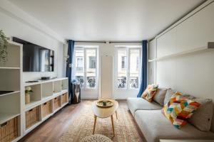 ein Wohnzimmer mit einem Sofa und einem Tisch in der Unterkunft SUPER CENTRAL - Sentier Studio - Air Conditioning in Paris