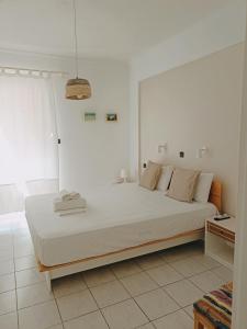 a white bedroom with a large bed in a room at Heras Garden in Vasiliki