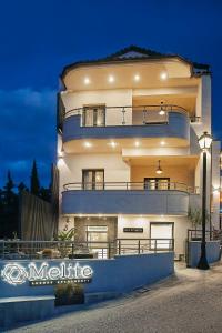 a large building with a lit up facade at night at Melite Luxury Rooms & Apartments in Paliouri