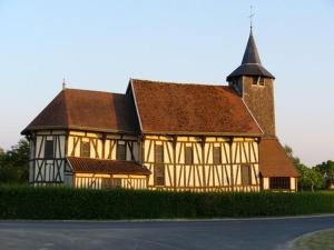 een groot gebouw met een bruin dak en een kerk bij Meublé de tourisme Le Gilliard in Chavanges