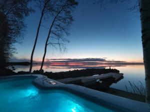 una piscina con vistas a un cuerpo de agua en Mukava pieni 2-4h mökki min 2 vrk Saimaan rannalla, poreallas, puusauna, Wi-Fi, Smart TV en Savonlinna