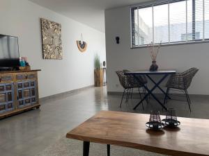 Casa Bamboo Tavira في تافيرا: غرفة معيشة مع طاولة وغرفة طعام