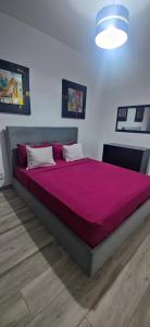 a bedroom with a large bed with a red blanket at Apartmentos Timas #1 in Praia