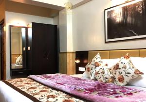 ein Schlafzimmer mit einem großen Bett mit Kissen in der Unterkunft Green Tara Homestay in Gangtok