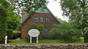 uma casa de tijolos com uma placa em frente em Dat Südstrandhuus- Ferienwohnung Silke em Wyk auf Föhr