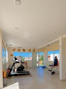 a room with a gym with a treadmill and chairs at Villa Paririö in Canoa Quebrada