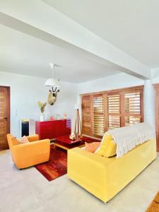 um quarto com uma cama amarela e um sofá em Villa Paririö em Canoa Quebrada