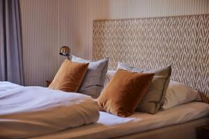 un lit avec quatre oreillers dessus dans l'établissement Rye115 Hotel, à Copenhague