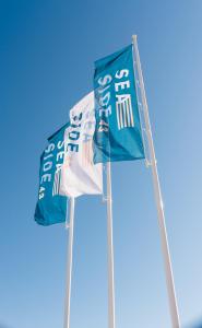 two flags flying in the blue sky at Seaside 43 in Sankt Peter-Ording