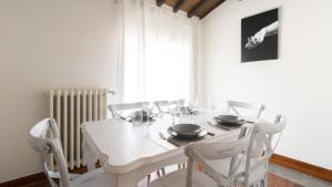 biała jadalnia z białym stołem i krzesłami w obiekcie Italianway - Barberini Elegantia Apartments Roma w Rzymie