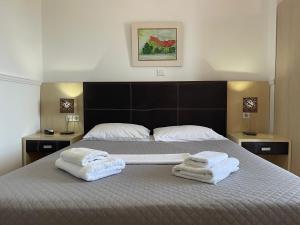 a bedroom with a bed with towels on it at Galini Hotel in Pefki