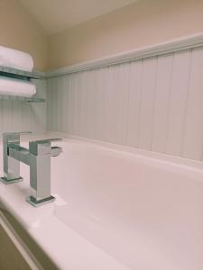 a bathroom with a bench and a sink at The Gwaelod y Garth Inn in Cardiff