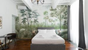 sypialnia z łóżkiem i muralem drzew w obiekcie Italianway - Barberini Elegantia Apartments Roma w Rzymie