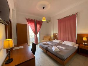 Schlafzimmer mit einem Bett, einem Tisch und einem Schreibtisch in der Unterkunft Galini Hotel in Pefki