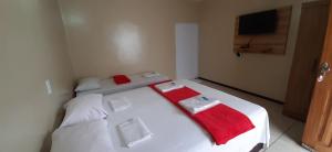 um quarto com 2 camas com toalhas vermelhas em Miraserra em Ubajara