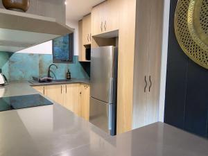 スレッドボにあるTyrola Eleven Thredboのキッチン(ステンレス製の冷蔵庫、木製キャビネット付)