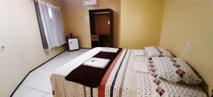 um pequeno quarto com 2 camas e uma janela em Miraserra em Ubajara