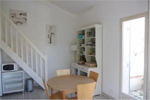 a dining room with a table and a staircase at Petite maison dans résidence avec piscine proche plage et centre ville à pied in Pornic
