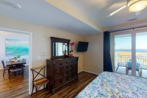 a bedroom with a bed and a dresser and a table at The Sanctuary - Sunset Haven B335 in Virginia Beach