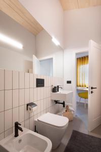 a white bathroom with a toilet and a sink at Camere d'Aria in Locana