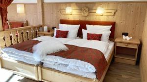 a bedroom with a large bed with white and red pillows at Rottach Apartments - Ferienwohnungen am Tegernsee in Rottach-Egern