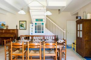 a dining room with a wooden table and chairs at "Primpolo" location pour 5 les pieds dans l'eau in Penmarch