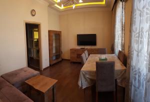 a living room with a table and a television at Central Baku Luxury Apartment on Nizami Street in Baku