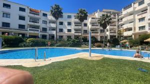 basen przed dużym budynkiem mieszkalnym w obiekcie Apartamento Golf Beach w mieście Benalmádena