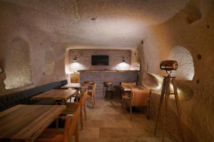 ein Restaurant mit Holztischen und -stühlen in einem Raum in der Unterkunft Maya Cave in Uchisar