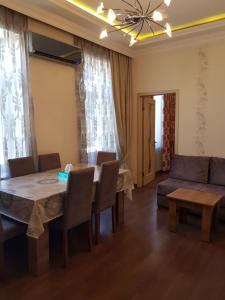 a dining room with a table and chairs and a couch at Central Baku Luxury Apartment on Nizami Street in Baku