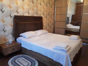um quarto com uma cama grande e um espelho em Central Baku Luxury Apartment on Nizami Street em Baku